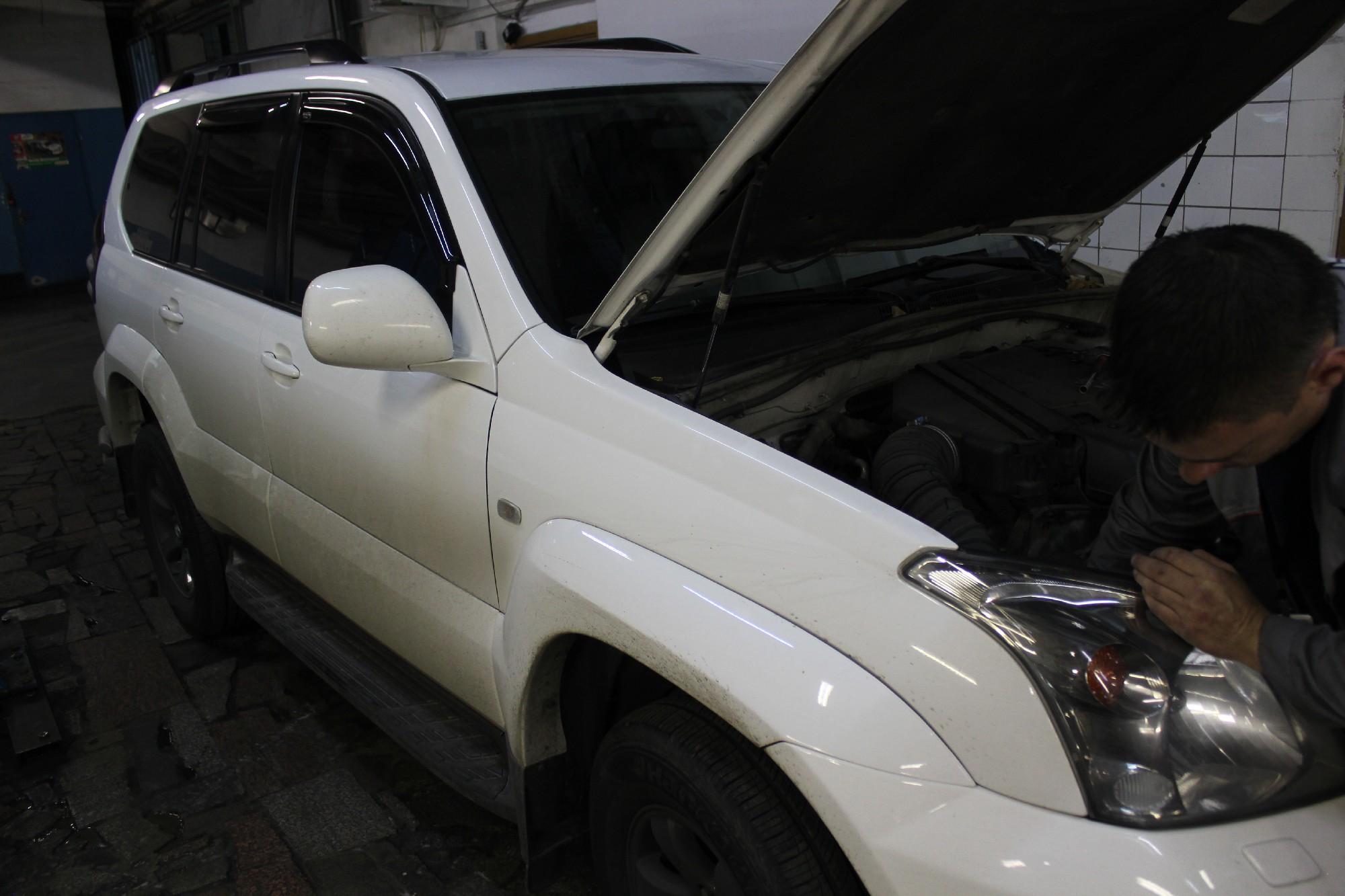 белый Прадо с открытым капотом