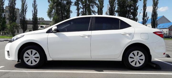 белая Королла седан сбоку