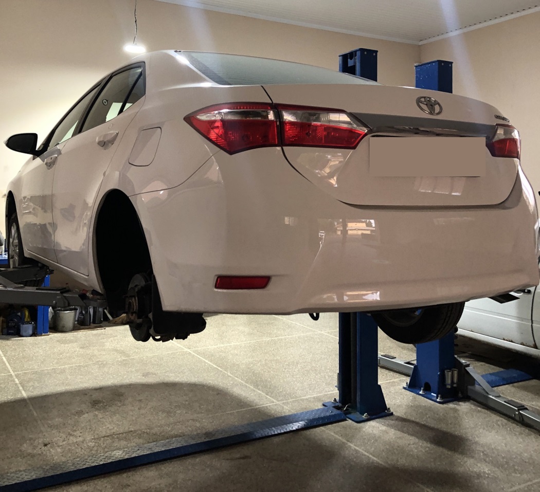 Тойота Королла в процессе замены тросов ручного тормоза